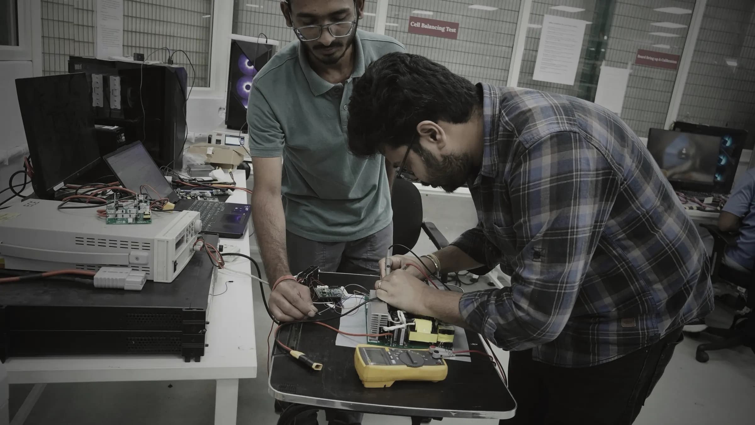 Engineers bringing up and calibrating a charger power board on the in-house test bench