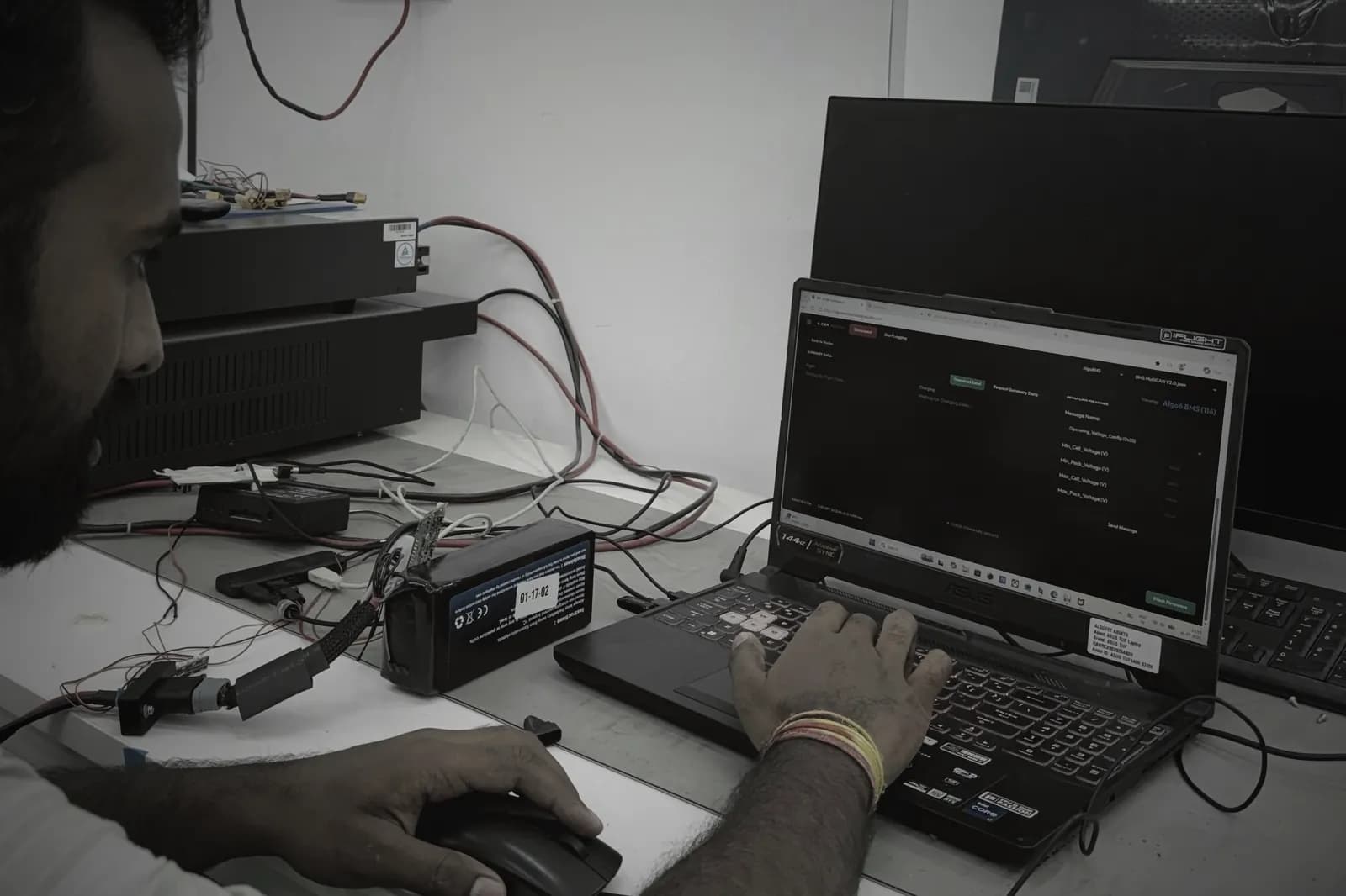 Engineer using the A-CAN tool to read an Algo6 BMS on a test battery pack